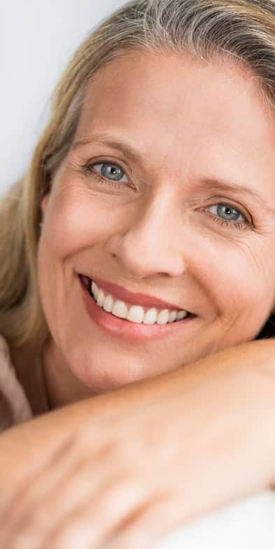 Facial Wrinkles Plano: Older blonde woman smiling at the camera