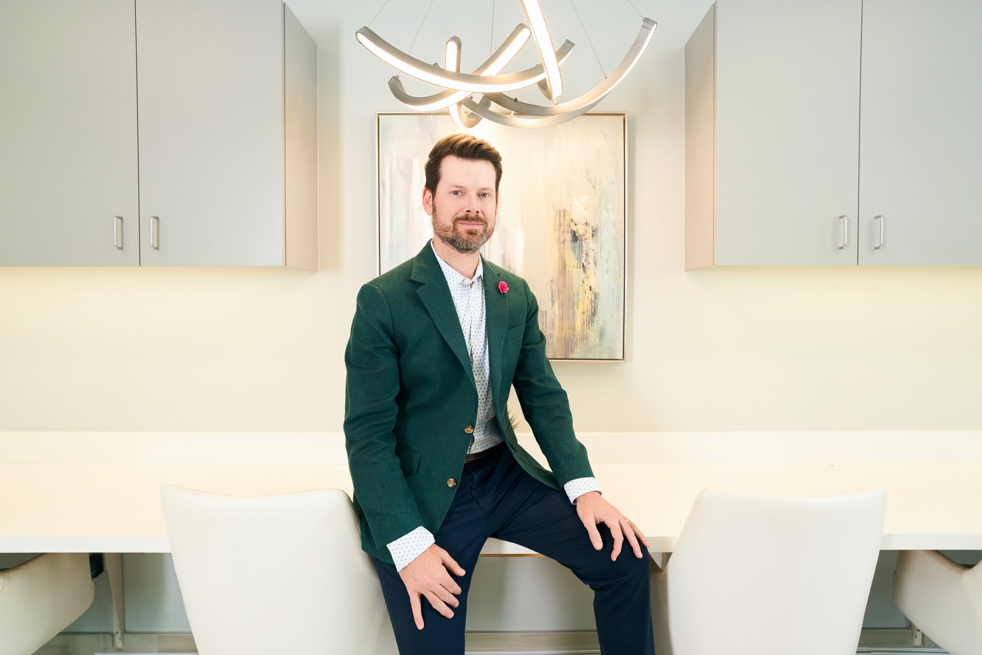 Microneedling In Dallas: Dr. Bader posing in front of painting in his clinic's hallway