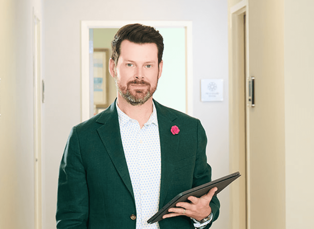 Dr. Bader holding a tablet in the office