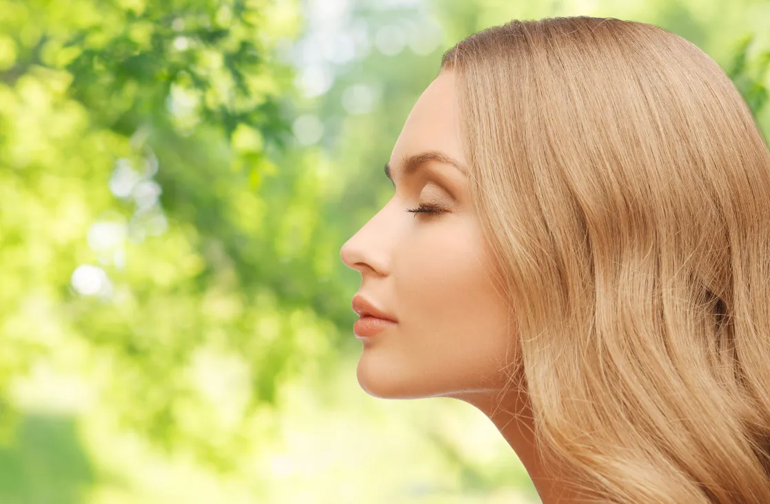 Septoplasty Procedure: Side profile of a young blonde woman in nature