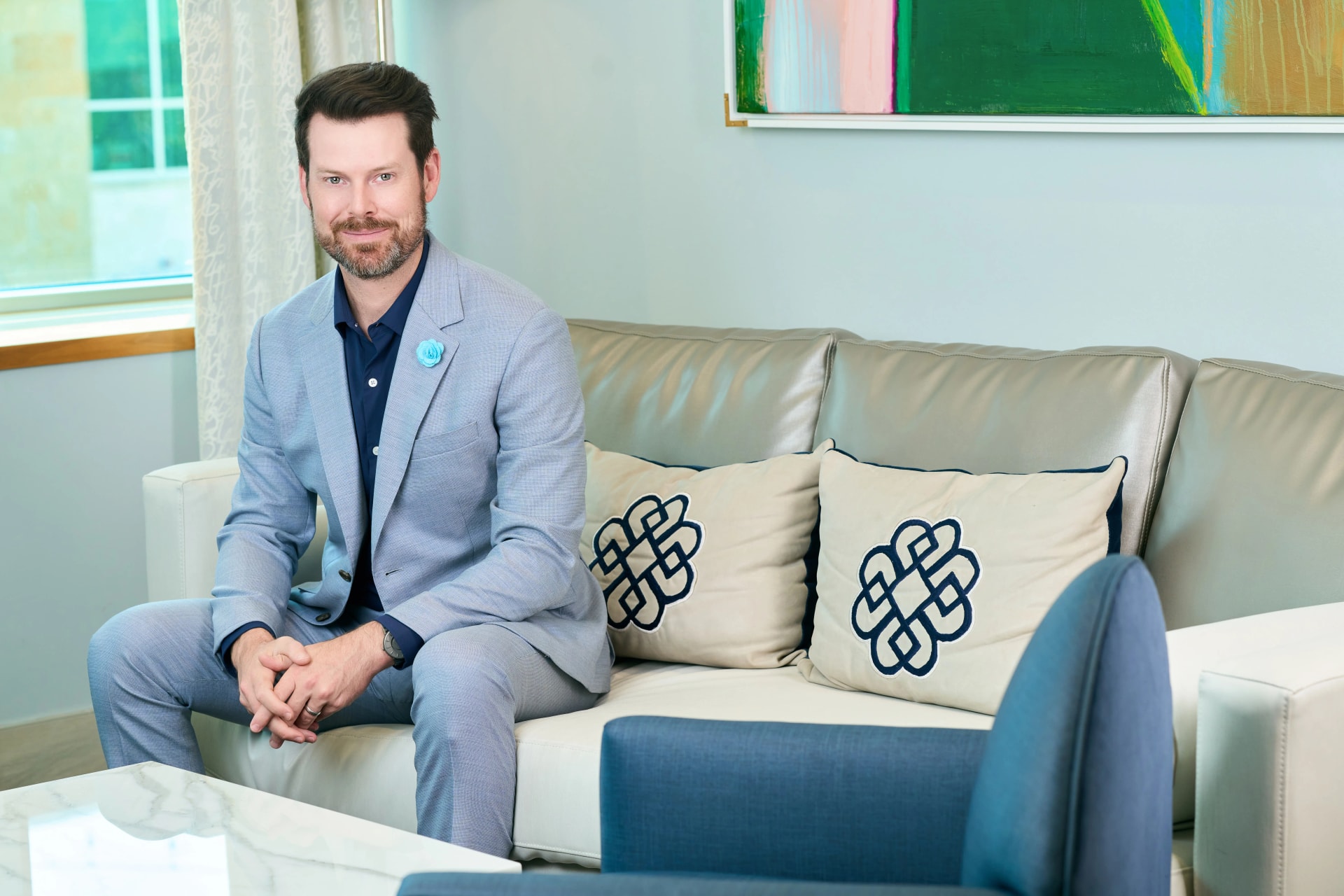 Facial Scar Treatment: Dr. Bader siiting on a couch in his office