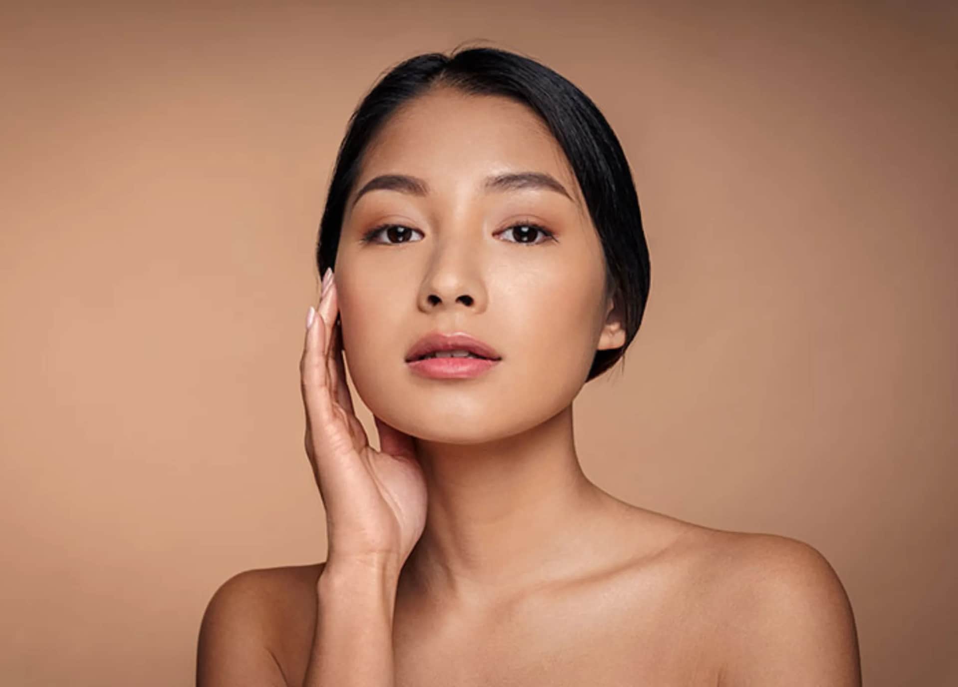 Ethnic Rhinoplasty in Plano TX: Asian woman looking at the camera while touching her chin