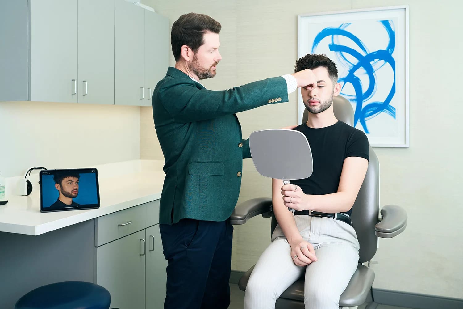 Crooked nose: Surgeon assessing a male patient's nasal symmetry during in-office consultation