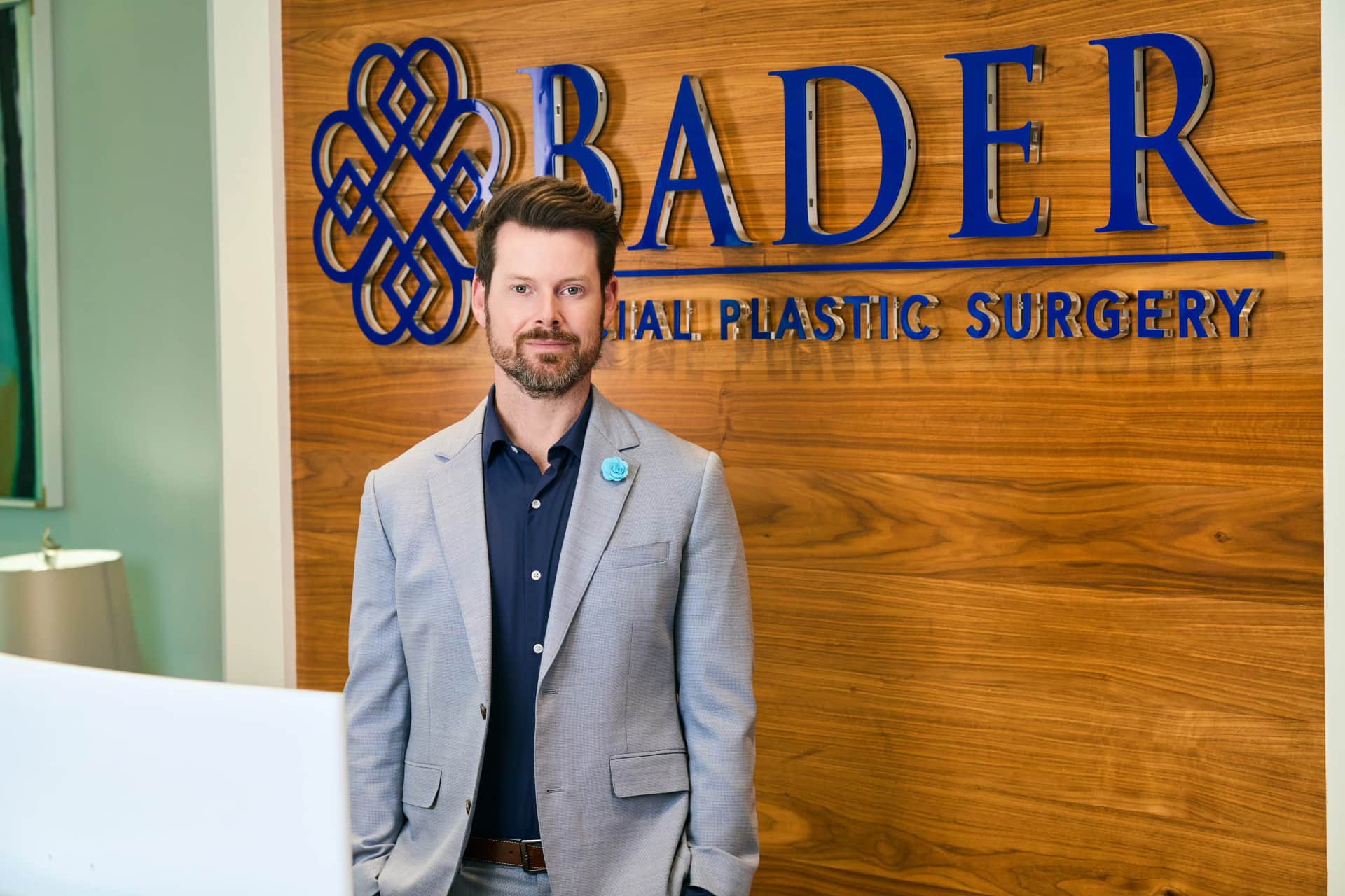 Tip Plasty Dallas: Dr. Bader standing in front of his reception at his office