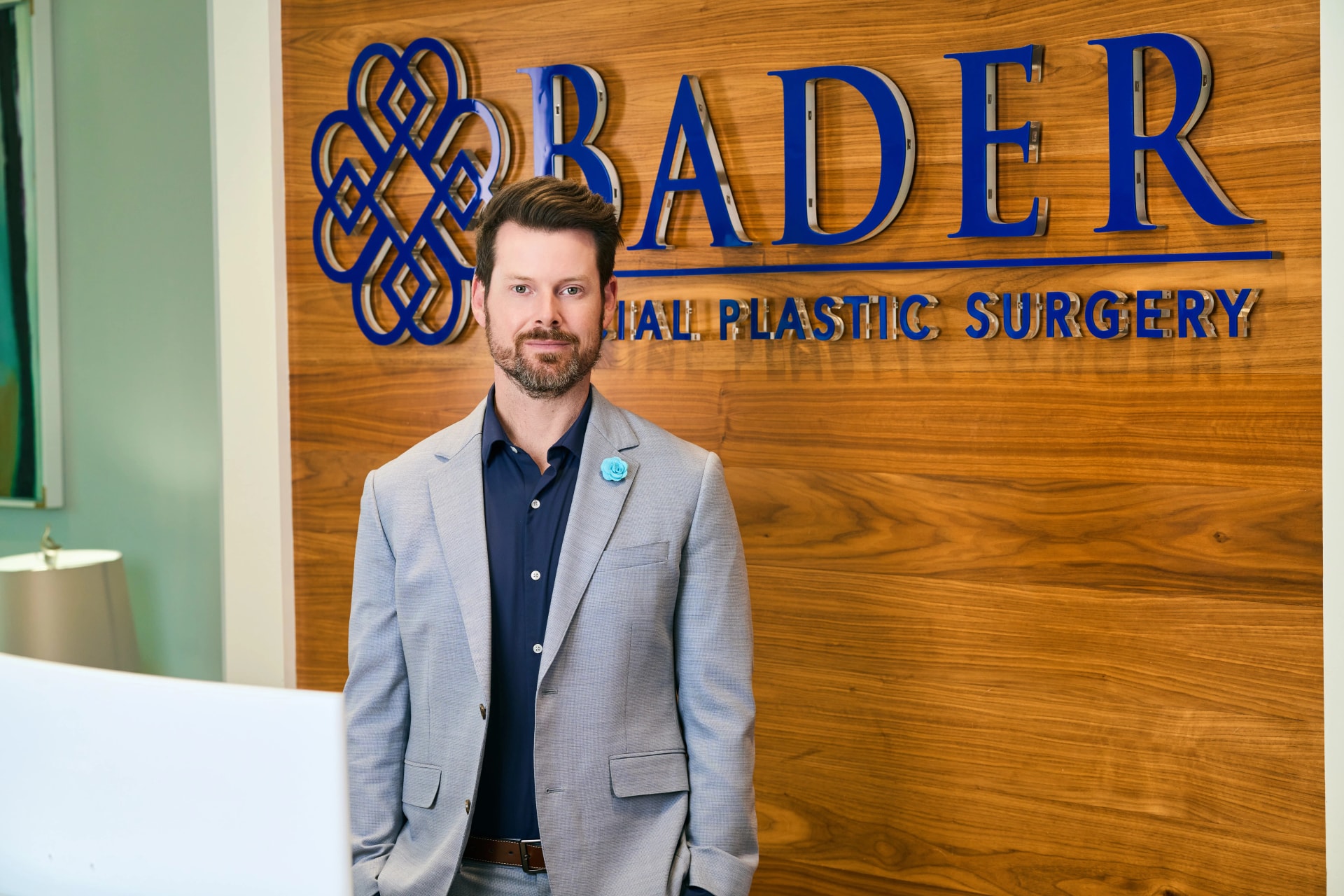 Tip Plasty Dallas: Dr. Bader standing in front of his reception at his office
