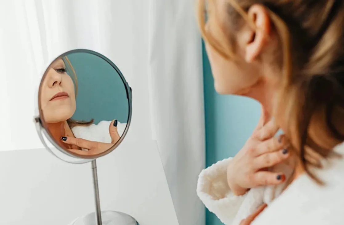 Facial Scar Treatment: woman looking at scar on mirror
