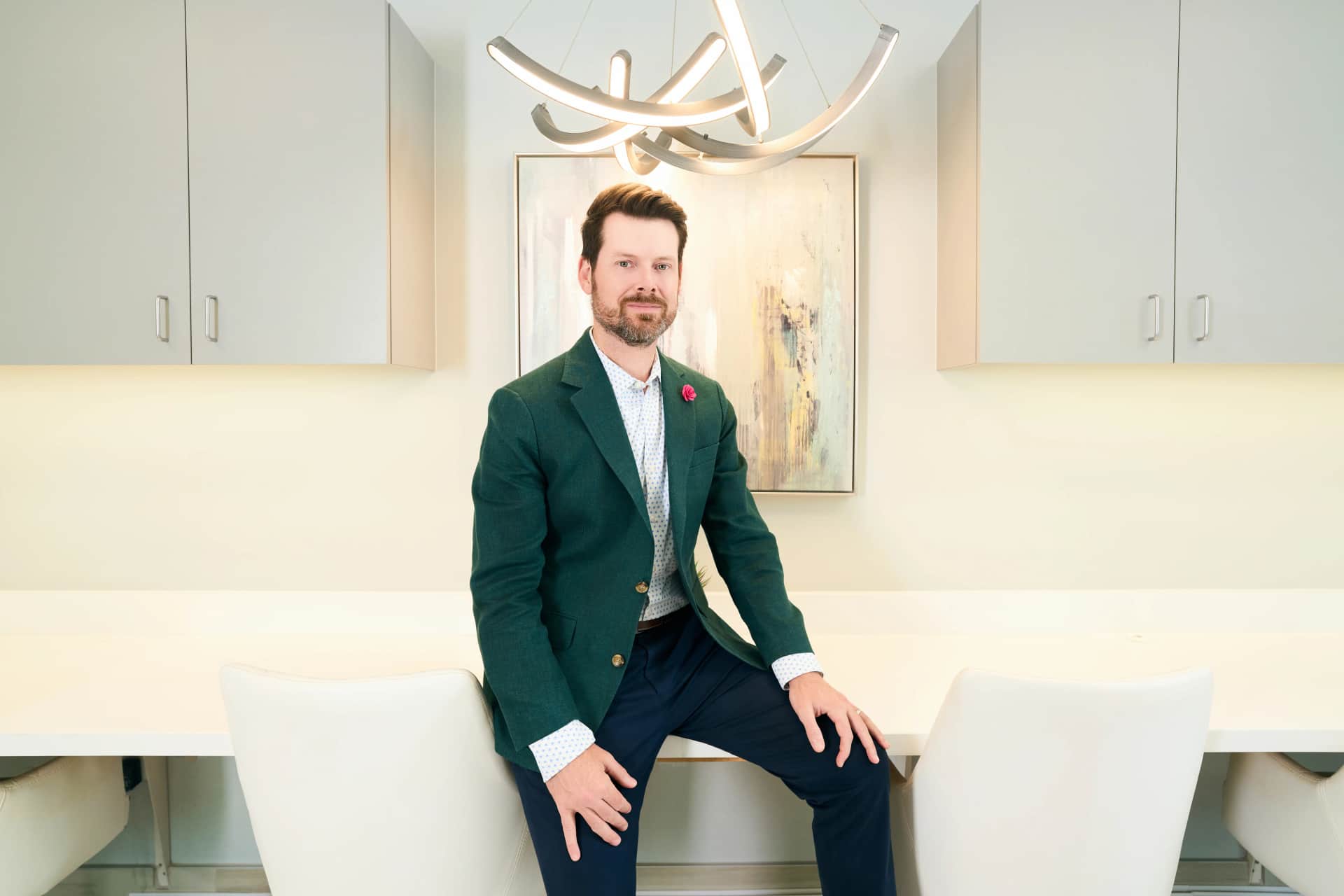 Septoplasty surgery Dallas: Dr. Bader sitting on a desk in his office posing for a picture