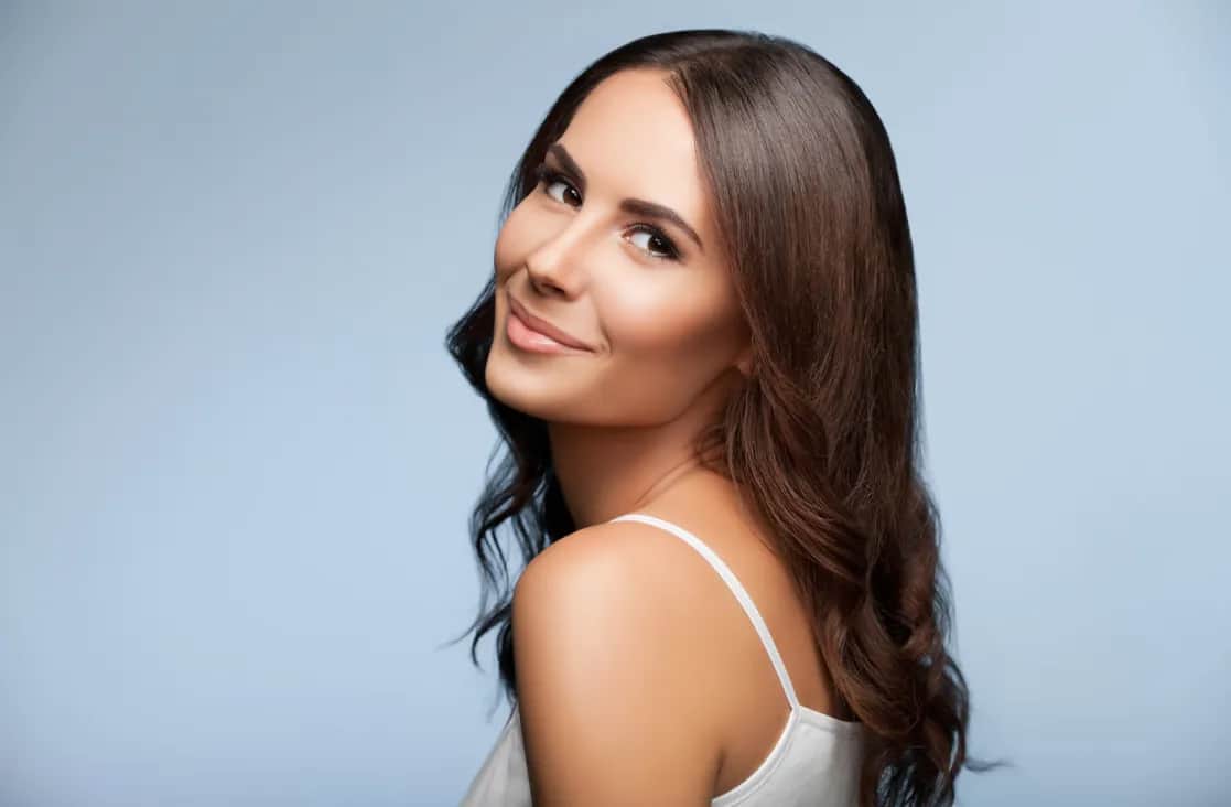 Alarplasty: Brunette woman looking over her shoulder towards the camera