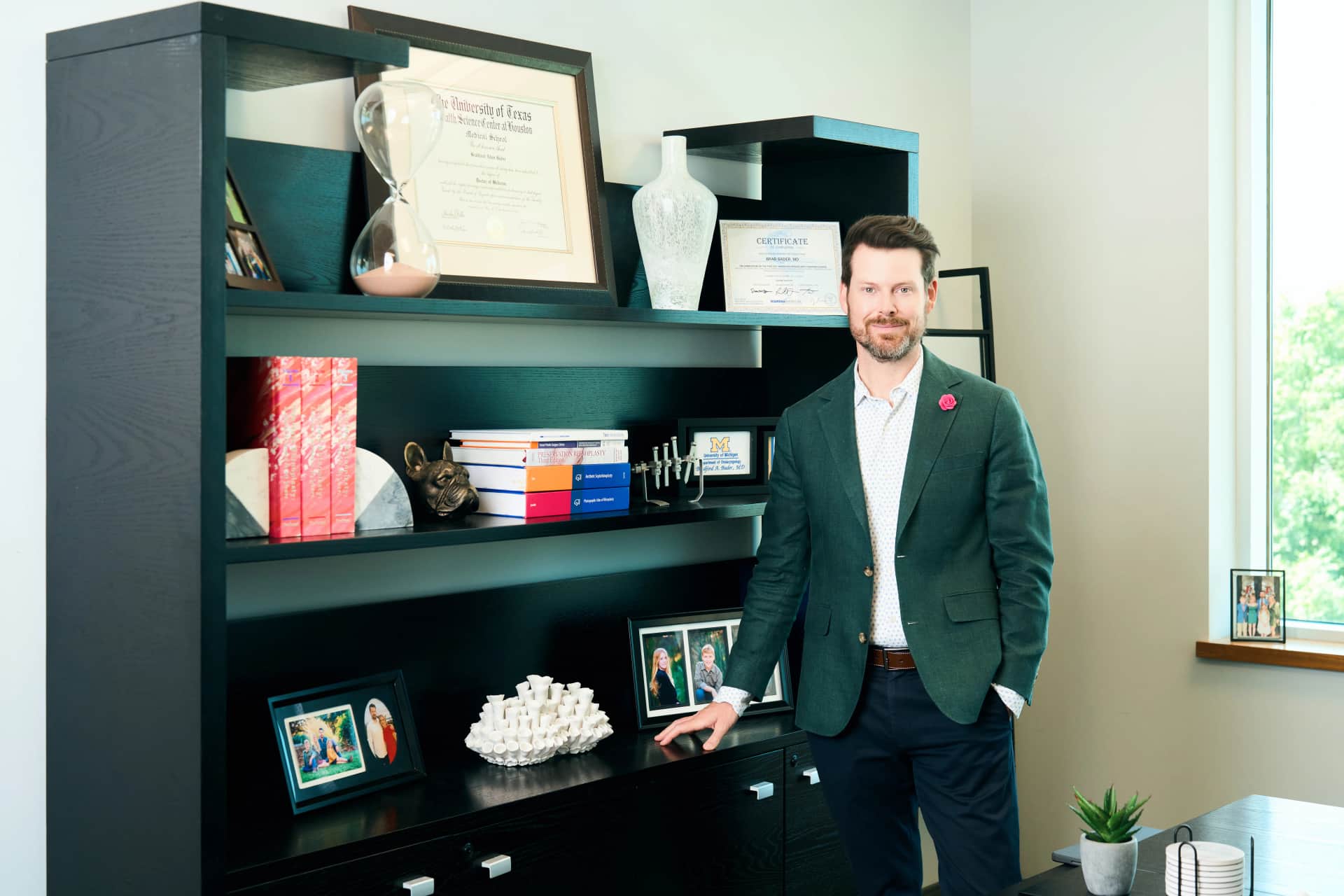Acne Scar Treatment: Dr. Bader standing in front of a shelf in his office