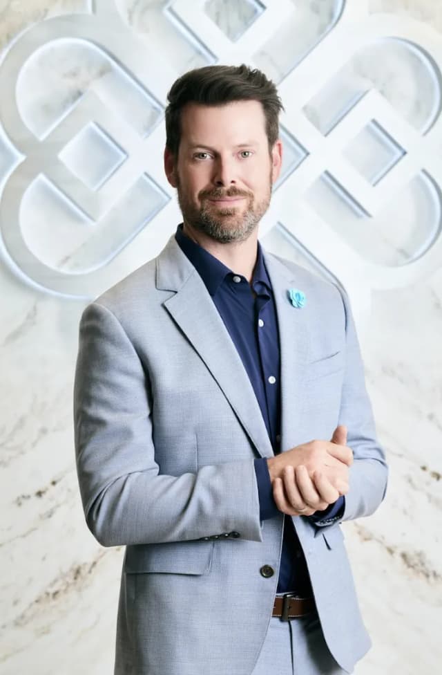 Facial plastic surgeon portrait in clinic setting wearing a light gray blazer and professional attire